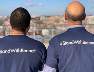 Two individuals wearing #StandWithBennett T-shirts