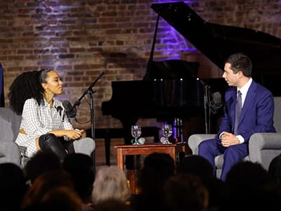 angela Rye and pete Buttigieg at table